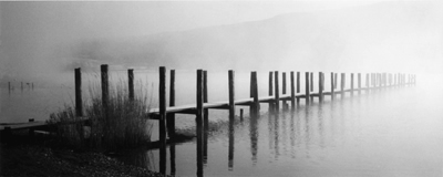 Wooden boat banding leading into in mist on Ullswater, Watermillock in Lake District