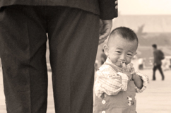 Small boy standing beside policeman in Tiananmen Square, 2000