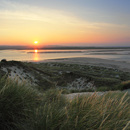 View of sunset over the dunes of Budle Bay from Budle Point, Northumberland, Northumbria